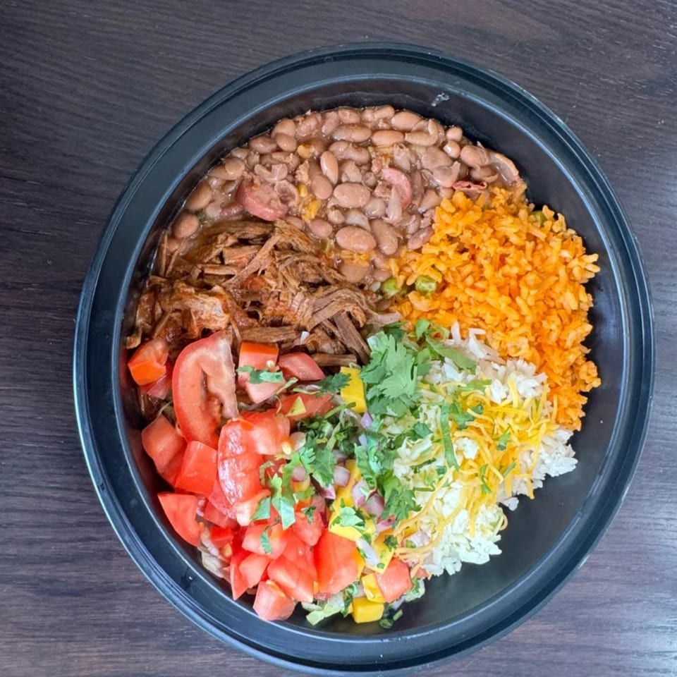 A Federales Street Tacos burrito bowl with beans, shredded beef, rice, tomatoes, and cheese.