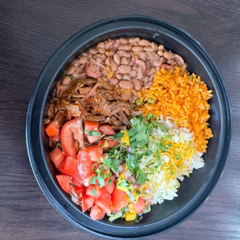 A Federales Street Tacos burrito bowl with beans, shredded beef, rice, tomatoes, and cheese.