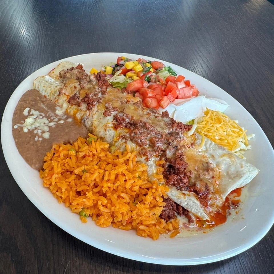 A large plate of Federales Street Tacos' Mexican food, including a burrito, rice, beans, and salsa.