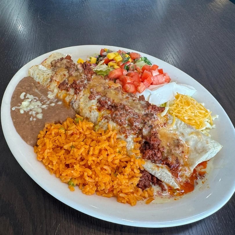 A large plate of Federales Street Tacos' Mexican food, including a burrito, rice, beans, and salsa.