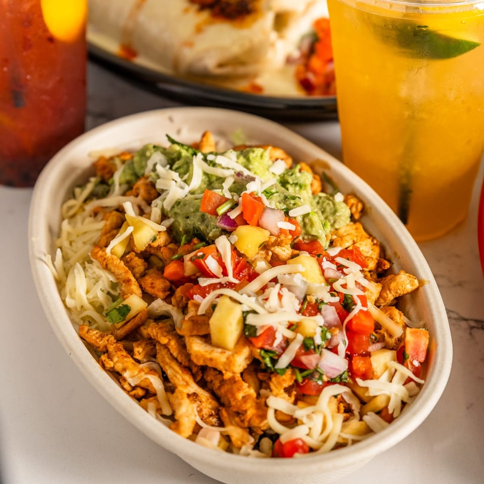 A Federales Street Tacos chicken bowl with guacamole, pico de gallo, cheese, and pineapple.